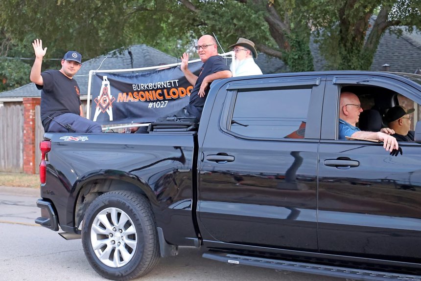 Participants waving from a black pickup with the Burkburnett Masonic Lodge No. 1027 banner